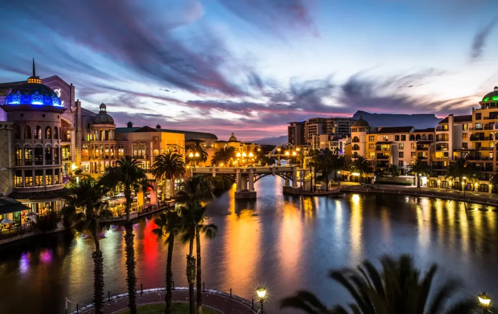 Beautiful buildings with there lights on at night and Table Mountain in the background
